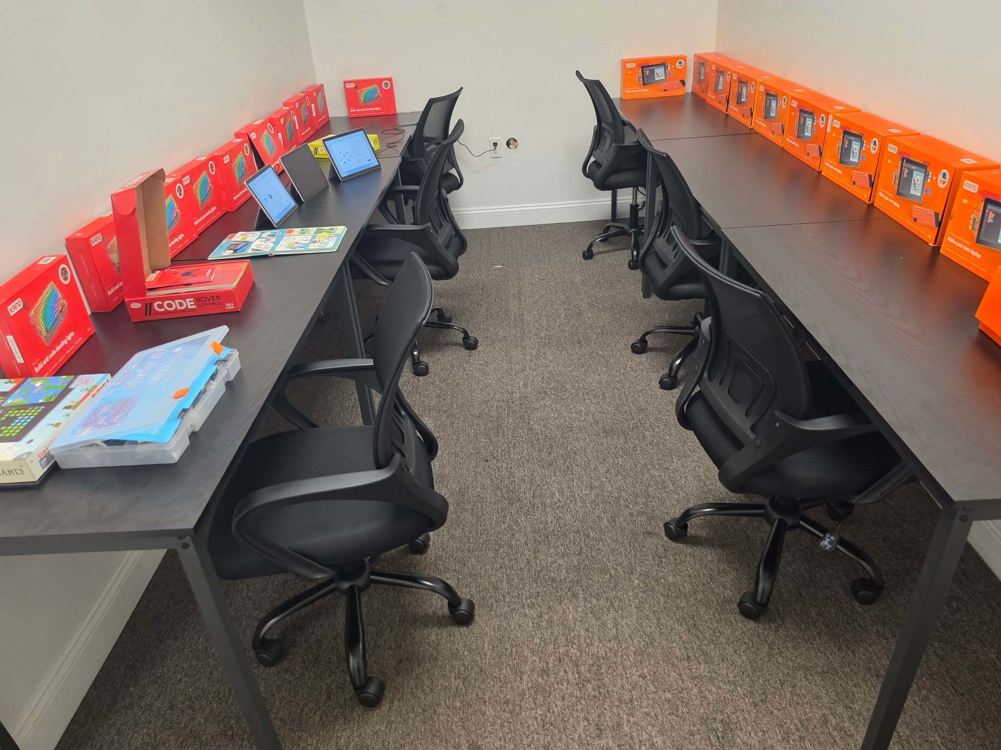 The RunTheCode coding room set up with laptops, activity kits, and workstations ready for students.