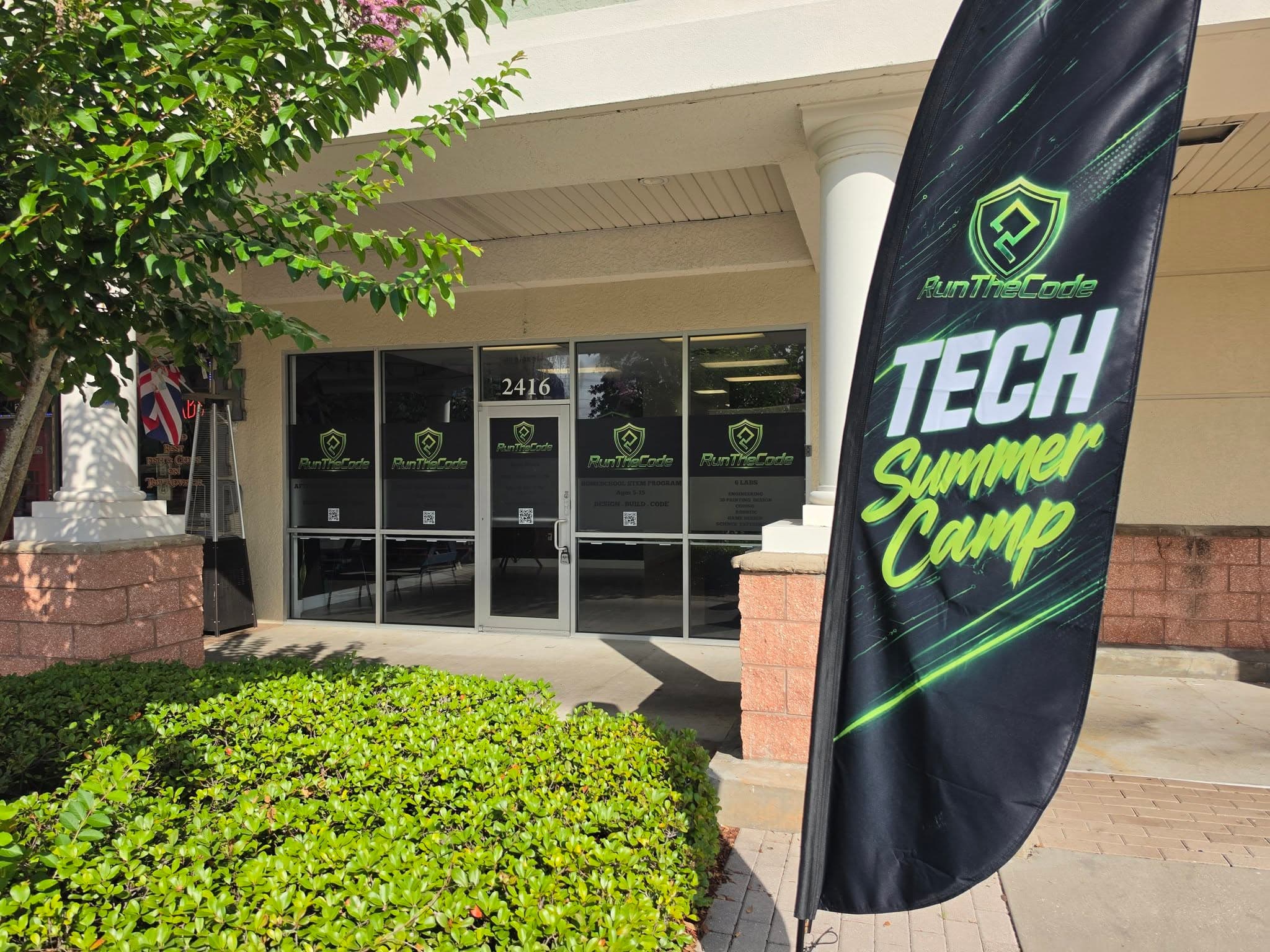 The RunTheCode storefront at 2416, with window decals listing the six labs and the front entrance.